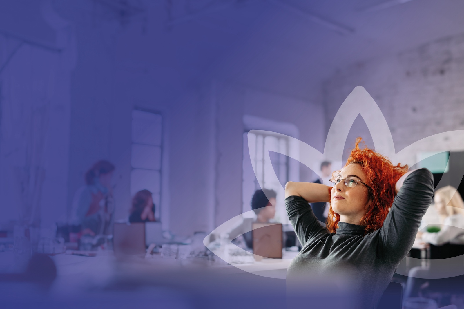 A red-haired professional young woman laying back in her chair with her arms behind her head. She is visibly at peace as she looks off into the distance.