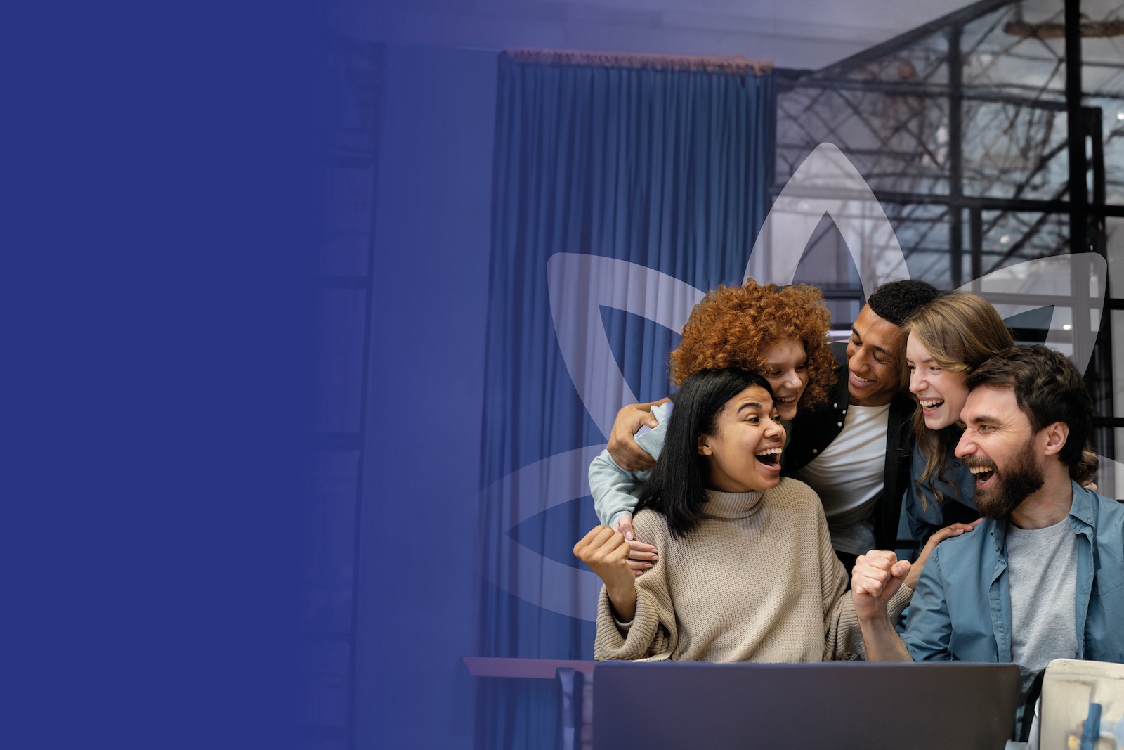 Five college students cheering together whilst sitting over a laptop.