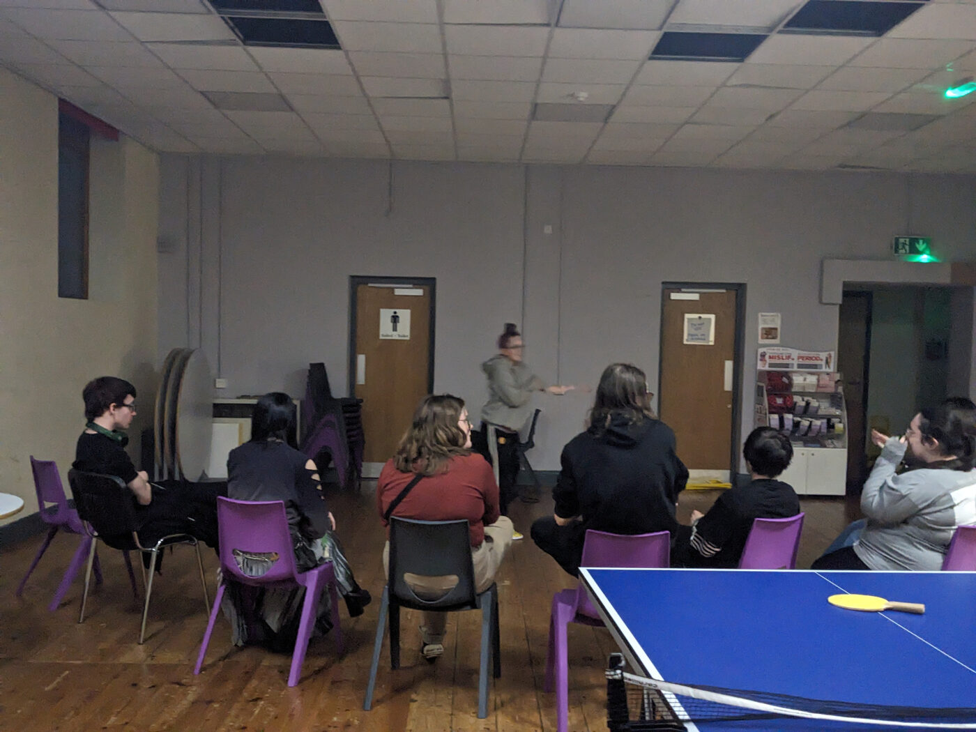 Young people sat in a group session, listening to a facilitator