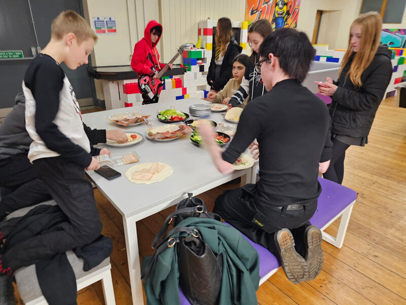 Young people preparing food together at a group session