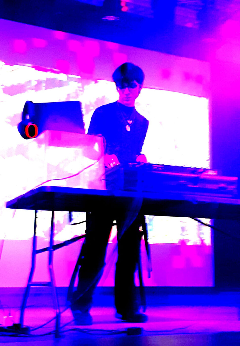 Cylo performing at a keyboard under purple stage lighting
