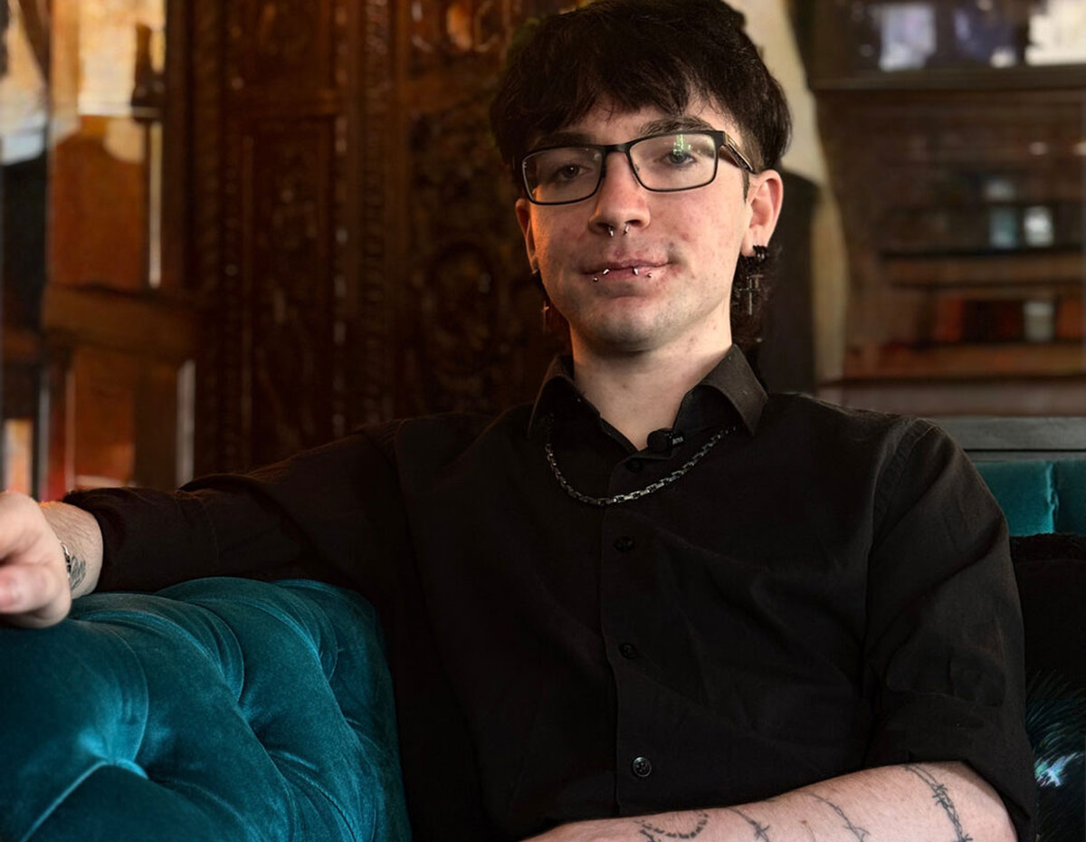 Cylo, seated on a teal velvet sofa